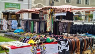 Verkaufsstand mit Kleidung, Gürtel und Kopfbedeckungen