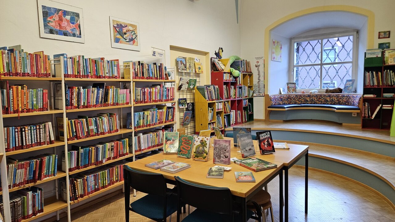 Ein Raum mit Bücherregalen an den Wänden und einem Tisch in der Mitten