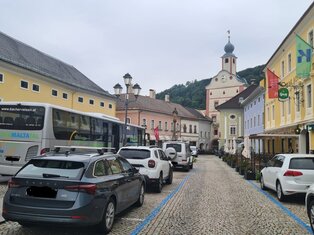 Blick von Mitte Hauptplatz Richtung Stadtturm Gmünd. Alle Parkflächen sind voll. Bei der Bushaltestelle steht ein Bus. Alles ist sehr eng
