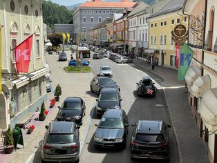 Die Durchfahrt durch das Untere Stadttor Blick vom Stadtturm Gmünd. Autos fahren in verschiedene Richtungen und stehen Schlange um das Stadttor passieren zu können
