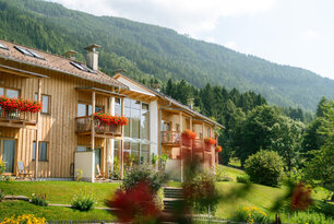 Ein großes Gebäude mit Holzverkleidung inmitten wunderschöner Natur.